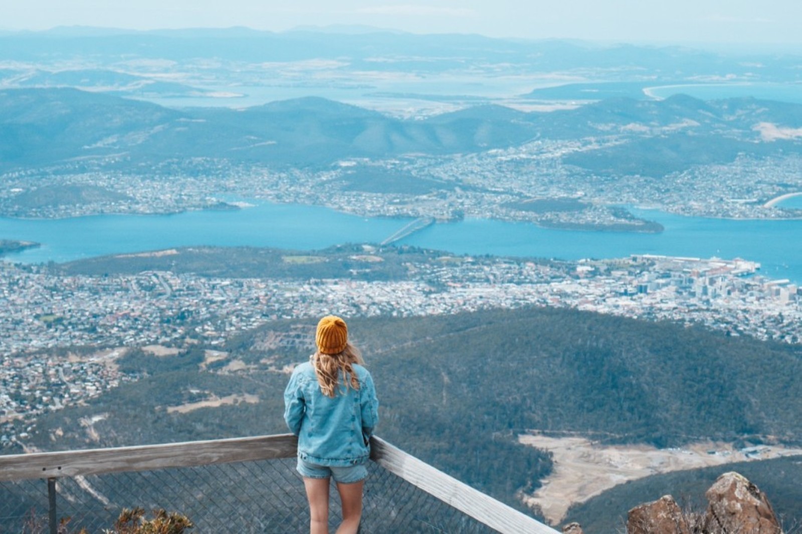 A woman stands at a lookout on Mount Wellington, gazing over Hobart and the Derwent River, one of the best things to do in Hobart.